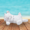 ready to paint ceramic kitten figurine lying on its back on a rustic table near the ocean.  Its feet are sticking out. Its tail is straight.